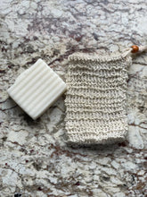 Load image into Gallery viewer, picture of beige sisal exfoliating bag with brown bead drawstring beside white lavender vanilla Cleansing Bar for size comparison on tan marble background