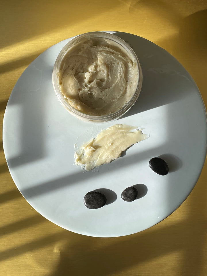creamy body butter with shadow and black rock props
